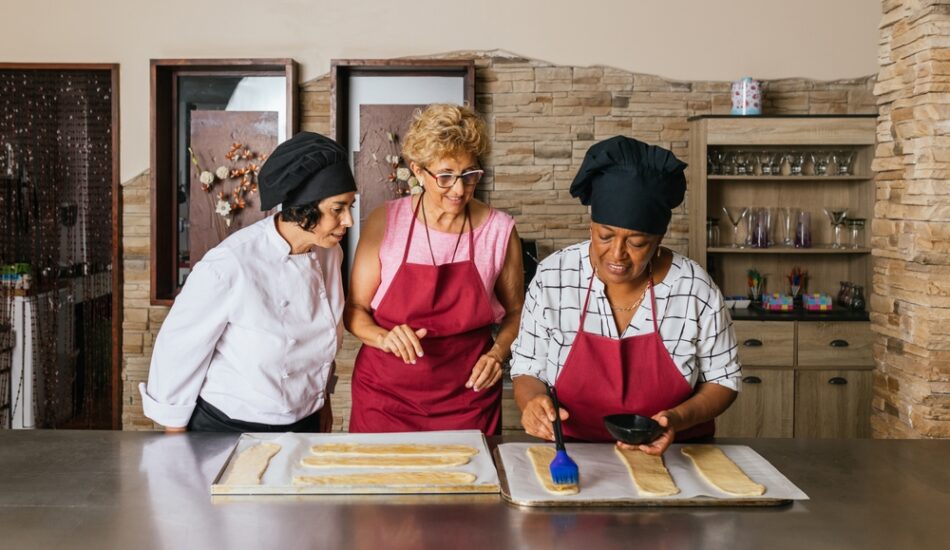 Twee vrouwen volgen een kookworkshop tijdens een culinaire vakantie.
