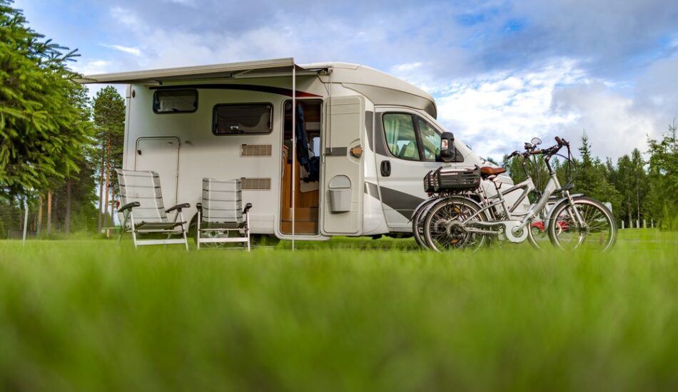 Een camper op een camping met gras.