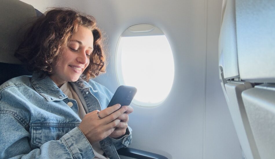 Een vrouw maakt gebruik van internet in het vliegtuig.